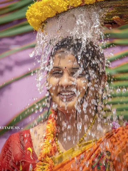 A high-shutter speed shot freezing the water droplets during a traditional bathing ritual. Capturing these dynamic moments of South Indian weddings is one of our specialties.