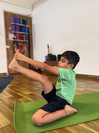 This young yogi is practicing Krounchasana, or heron pose, which is a deep stretch for the hamstrings. His focus and dedication are wonderful to witness.
