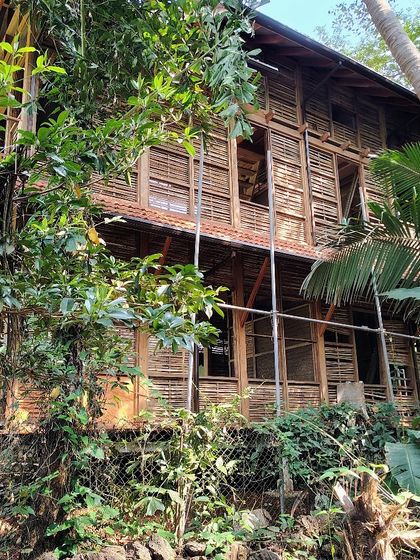 The cottage under construction, showing the intricate pattern of the wattle-and-daub walls before the final plaster layer is applied.