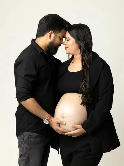 An intimate and modern studio portrait of an expecting couple, focusing on their connection and the beautiful baby bump. This simple, clean style creates timeless and emotional pregnancy photos.