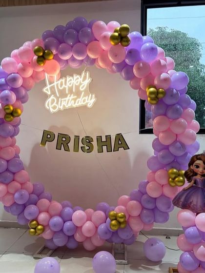 A detailed shot of the princess party's circular balloon arch, showing the mix of pink, purple, and gold balloons.