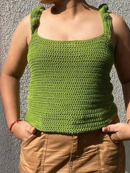 Our ruffle top in a vibrant green. The delicate ruffles on the straps add a sweet, feminine detail to this simple tank top.