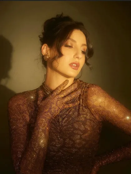 For her appearance on Jhalak Dikhhla Jaa, I put Nora Fatehi in this shimmering, form-fitting gown by Itrh. The ruched fabric and built-in gloves create a sophisticated and high-fashion television look.