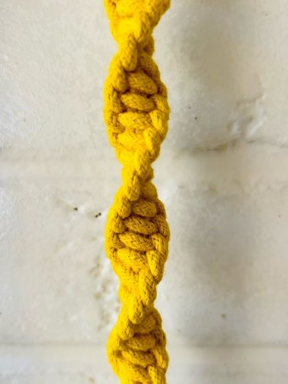 A close-up of the half-square knot spiral we use in our macrame creations, like this 'Mac & Chime' wall hanging. It's a simple yet beautiful technique that adds a unique texture to our pieces.
