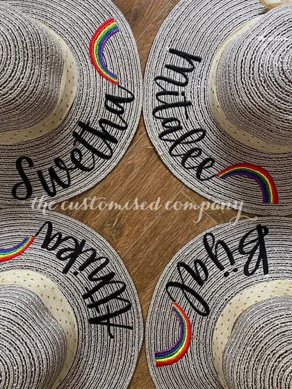 Stay stylish and sun-safe on your holiday getaway. These chic sun hats feature personalized names and a cute rainbow patch, adding a touch of color and fun to your beach look.