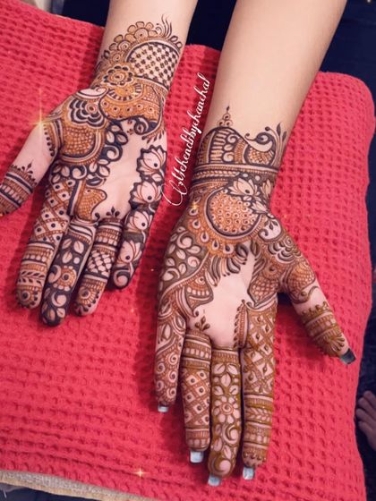 An intricate design with a mix of styles. One hand has a more traditional Indian pattern, while the other features a modern Indo-Arabic look.