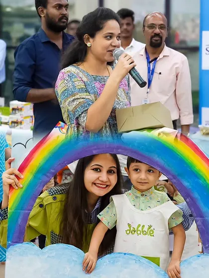 That "I made this!" smile is what we live for. A proud young artist poses with his mom under a rainbow prop after a fun-filled session of painting and creating.
