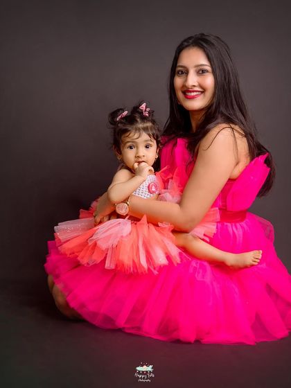 A beautiful seated portrait of a mother holding her daughter close. The coordinated outfits and loving embrace make this a timeless keepsake.