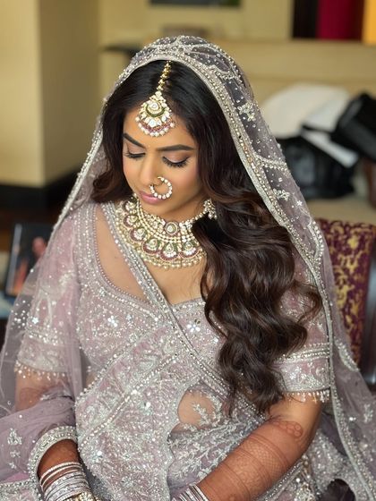 A serene portrait of the bride. The soft lighting enhances the ethereal quality of her pastel look.