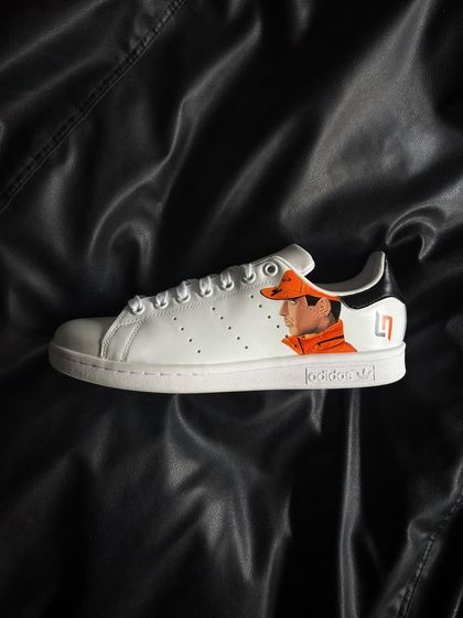 A side profile of the other shoe, featuring a detailed portrait of Lando Norris in his McLaren gear.