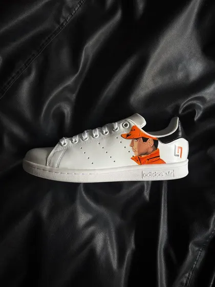 A side profile of the other shoe, featuring a detailed portrait of Lando Norris in his McLaren gear.