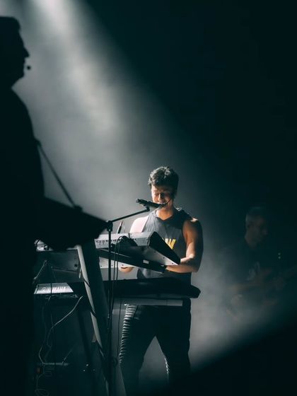 A silhouette of a keyboardist on stage, highlighting the professional musicians that are part of the Salim-Sulaiman live experience.