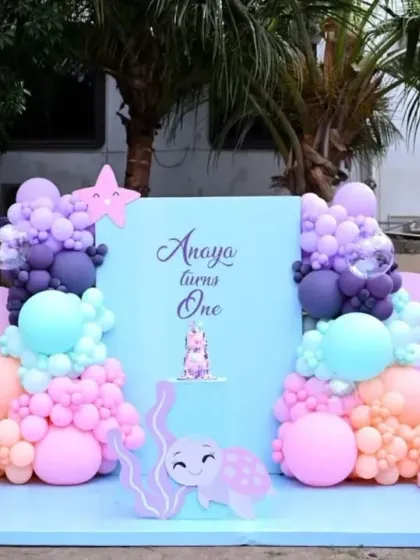 An enchanting 'Under the Sea' theme for Anaya's first birthday, featuring pastel pink, purple, and blue decor, a giant seashell prop, and cute sea creature cutouts.