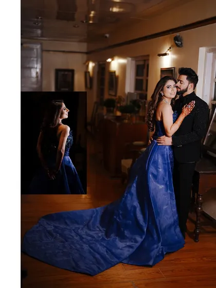 A dramatic portrait of a couple at their engagement party. The bride's royal blue gown with a long train makes a stunning statement in the elegant, wood-paneled room.