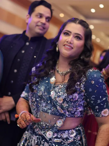 The bride enjoying the dance performances at her Sangeet, her expression full of happiness and excitement.