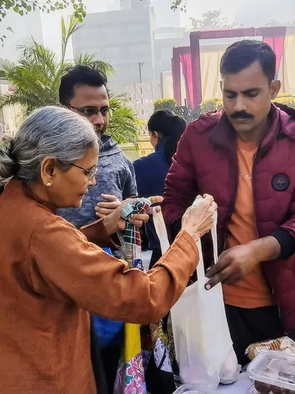 A customer receiving her purchase in a cloth bag, a common sight at the market.