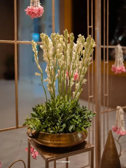A simple arrangement of tuberoses in a brass pot, yet it adds so much elegance. It's the thoughtful placement of these details that elevates the entire venue.