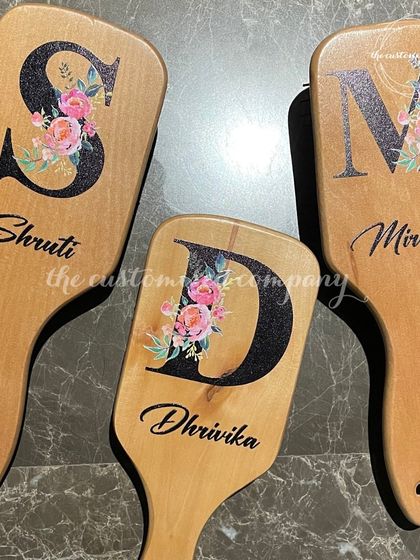 A perfect gift for your bridesmaids. These wooden hairbrushes are beautifully customized with a floral monogram initial and their name in script.