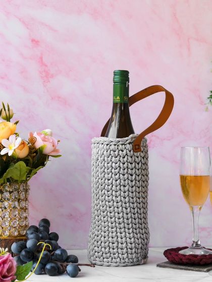 Another elegant shot of the gray wine carrier, this time with a different floral arrangement and lighting, showcasing its sophisticated design for gifting or special occasions.