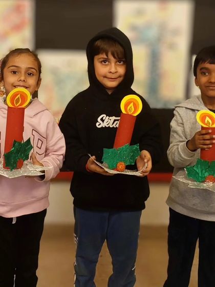 A trio of young artists showing off their completed Christmas candle holders. It was a fun, hands-on project for everyone.