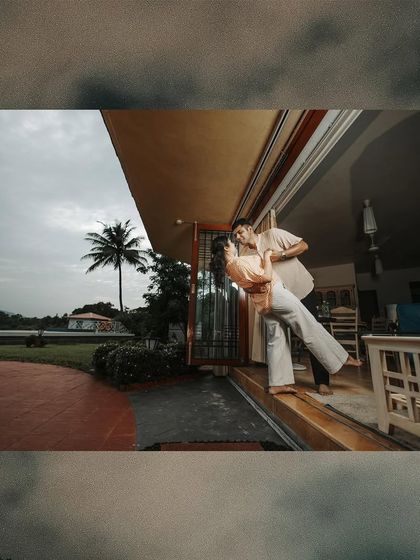A playful and romantic shot of a couple dancing on the porch of a beautiful house, capturing a fairy-tale moment.
