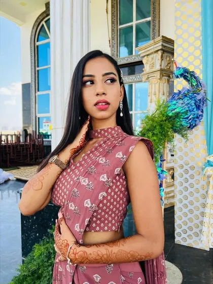 A confident pose showing off the full look. The modern, pre-draped saree and chic makeup make for a perfect engagement guest outfit.