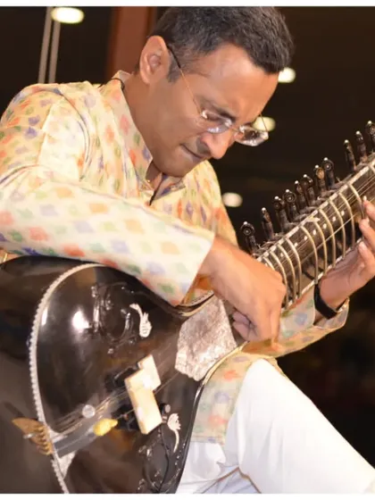 Tuning the sitar before a performance, a crucial part of preparing for the perfect sound in an intimate space.