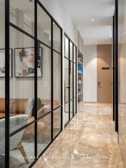 This corridor is more than just a passageway; it offers views into beautifully designed lounge areas, making the journey through the office a visually engaging experience.