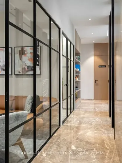 This corridor is more than just a passageway; it offers views into beautifully designed lounge areas, making the journey through the office a visually engaging experience.