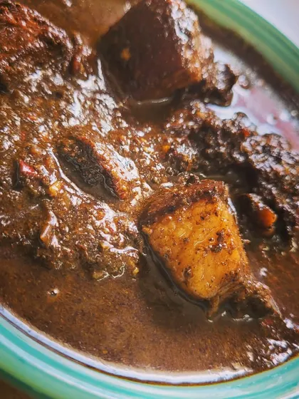 A close up shot of the Anishi with Pork. The texture of the gravy is thick and luscious, clinging to every piece of pork. This is a must-try for adventurous food lovers.