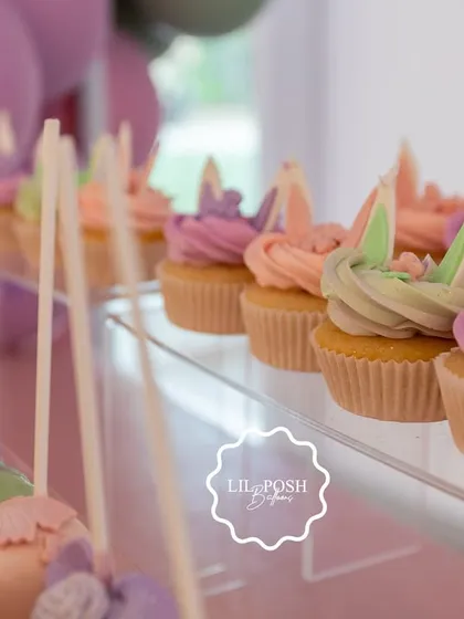A close-up of the pastel cupcakes and cake pops, each decorated with whimsical bunny ears and floral details.