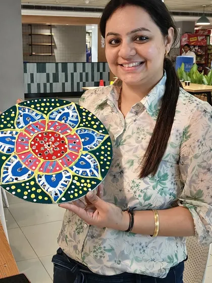Another proud artist showcasing her completed Lippan art. Each piece is unique, reflecting the personal style and creativity of its maker.