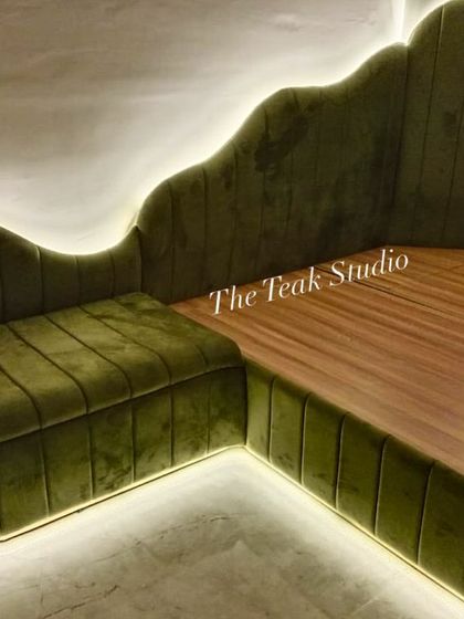 Another angle of the custom olive green corner bed, highlighting the beautiful scalloped shape and the warm glow from the integrated LED lighting.