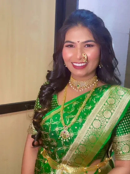 A happy client showing off her beautiful smile and flawless traditional makeup, complete with a Maharashtrian nath.