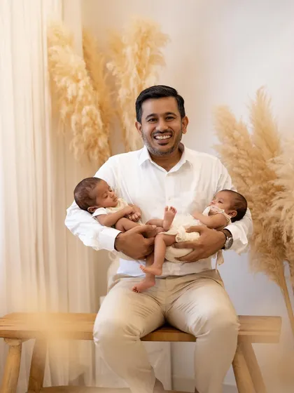 A happy father holding his twin babies. These portraits are not just for today but are heirlooms that will be cherished for generations to come.