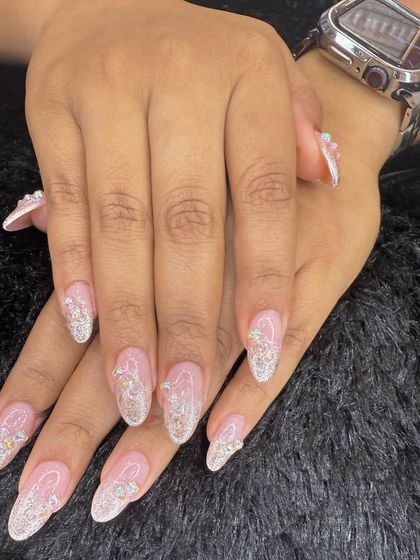 Long, elegant, and full of sparkle. This almond-shaped set features a sheer pink base with a cascade of silver glitter, creating a glamorous and eye-catching effect.