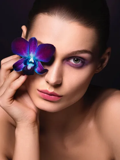 A simple yet striking look where a single, vibrant orchid becomes the centerpiece, complementing the subtle purple eyeshadow.