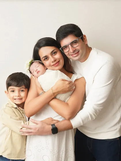 The complete family of four, smiling for the camera. This portrait is a beautiful announcement of their new family dynamic, full of joy and love.