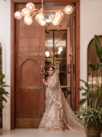 Vidhi making her entrance, a moment of anticipation as she stands at the door. The grand setting and her stunning outfit create a powerful image of a bride ready to begin her new chapter.