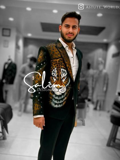 A client wearing a dark green blazer with a hand-painted and embroidered leopard face. The combination of painting and texture gives the design a lifelike quality.