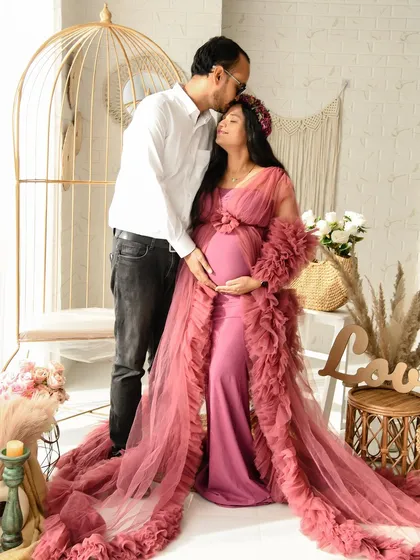 A romantic moment captured in our sunlit boho studio. The partner's gentle kiss on the forehead and the beautiful dusty rose gown create a soft and dreamy portrait.