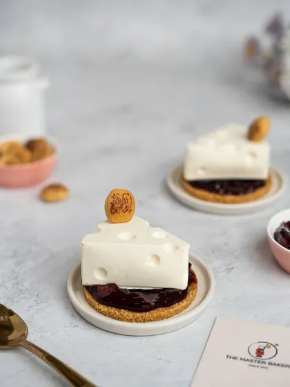 We love to have fun with our desserts. Our Wild Cherry Cheesecake is a playful twist on a classic, crafted to look like a wedge of cheese, complete with a buttery crumble base and a rich wild cherry compote filling.