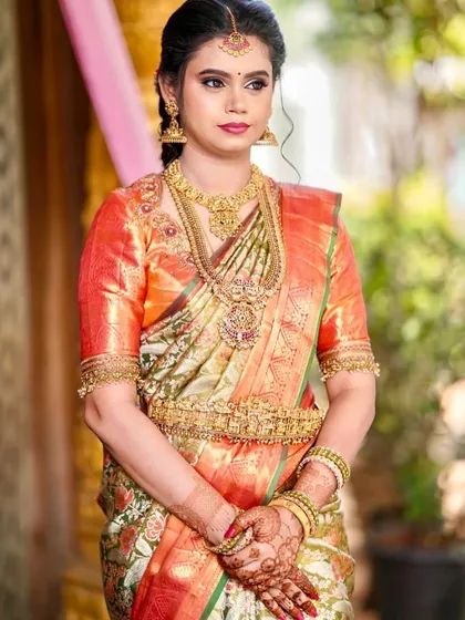 A client looking beautiful in a classic Meenakari designer silk saree, known for its colorful enamel work.