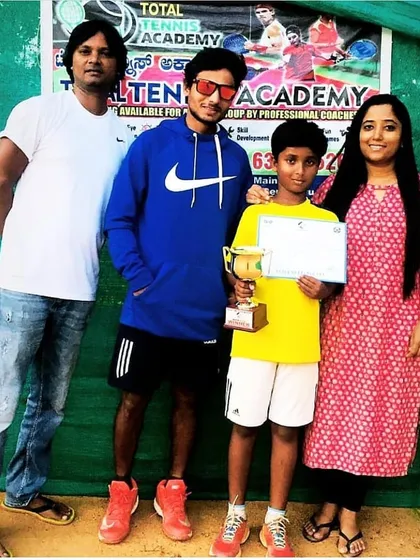 We are incredibly proud of our players' achievements. Here is one of our junior champions with his family after winning a tournament, a testament to his hard work and the supportive community at our academy.