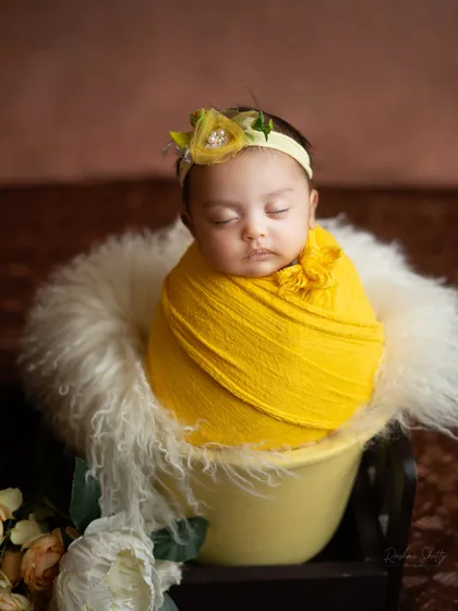 A little ray of sunshine wrapped in a vibrant yellow swaddle. This simple setup on a miniature bed prop is both sweet and elegant.