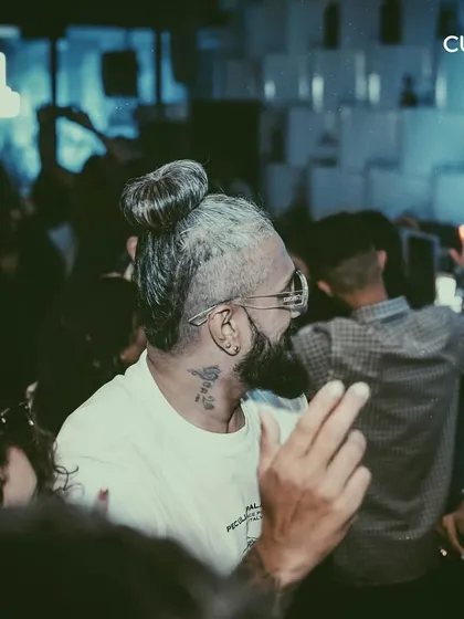 A guest with a stylish haircut and tattoos enjoying the vibe. My events attract a diverse and trend-setting crowd.