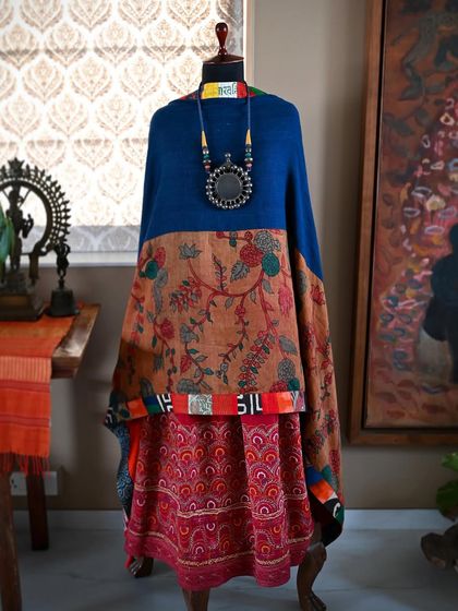 A full view of the shawl worn as a poncho, demonstrating its versatility. The combination of prints and textures creates a statement piece that is both artful and functional.