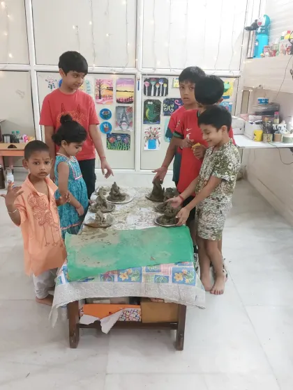 The proud moment when the children display their finished Ganesha idols together. This group activity fosters a sense of shared accomplishment and community during the festive workshop.