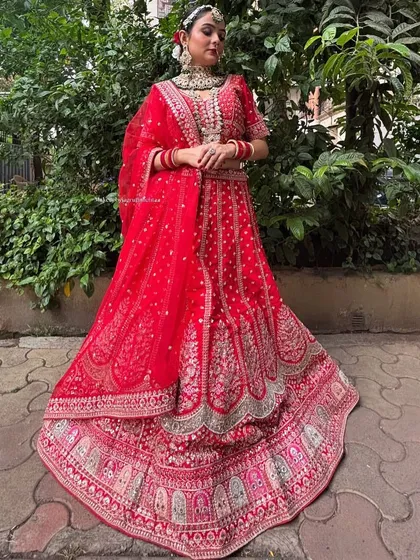 A classic red bridal lehenga with intricate gold embroidery. This timeless piece is perfect for the main wedding ceremony.