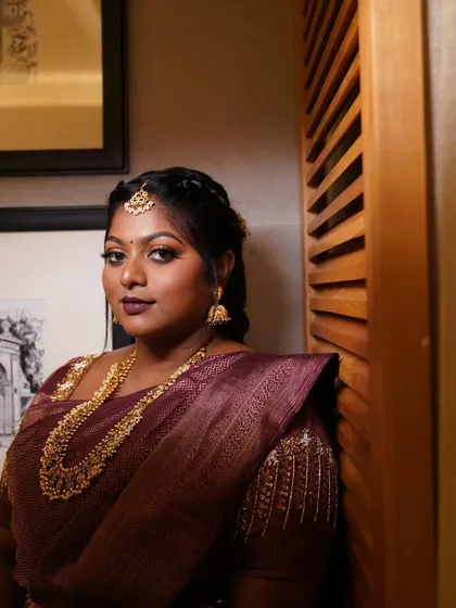A portrait of Dr. Preetha, looking regal and confident. The deep wine lips and coppery eyes are a powerful combination.